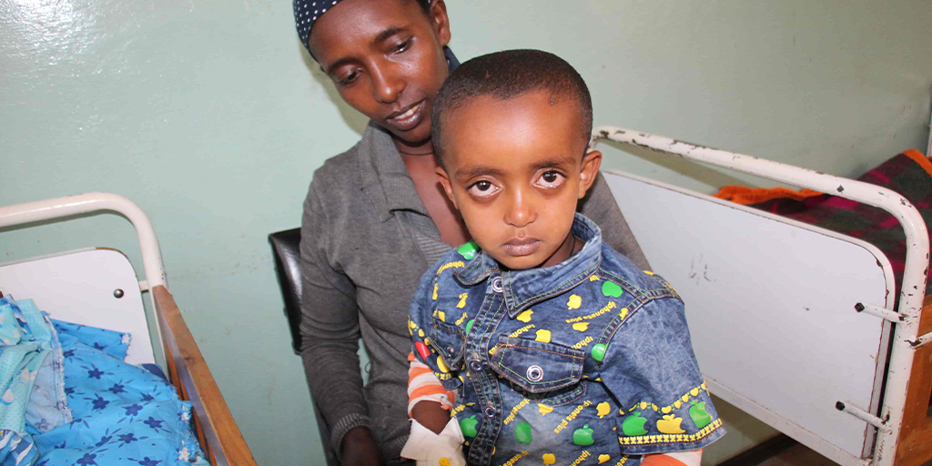Mother holding her child in an African health clinic.